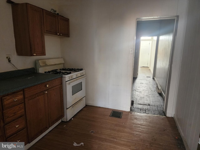 kitchen with white range with gas cooktop and dark hardwood / wood-style floors