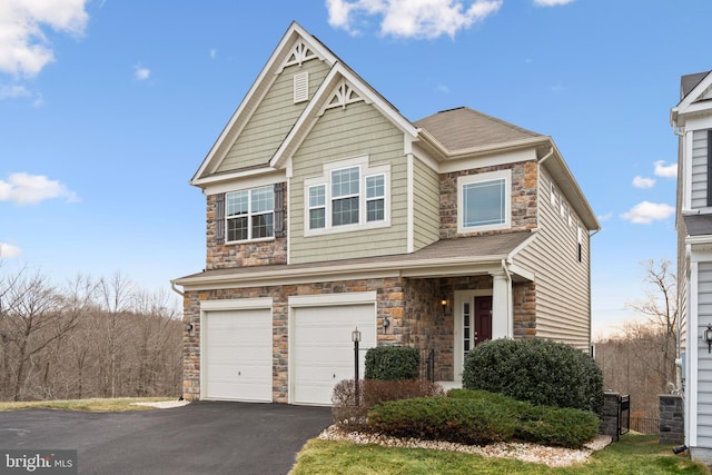 craftsman inspired home with stone siding, aphalt driveway, and an attached garage