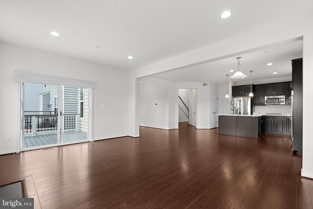 unfurnished living room with baseboards, dark wood-style flooring, and recessed lighting