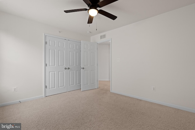 unfurnished bedroom with light carpet, a closet, visible vents, and baseboards