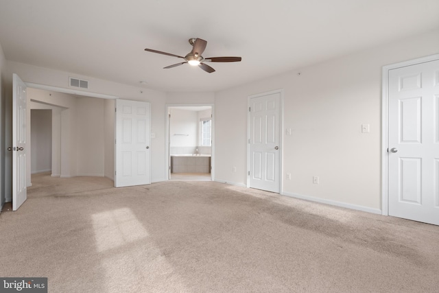 unfurnished bedroom with baseboards, visible vents, ensuite bathroom, and light colored carpet