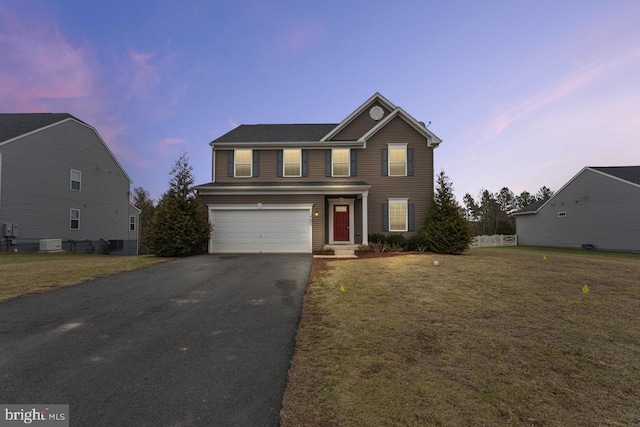 view of front property with a garage and a lawn