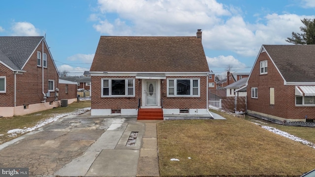 bungalow with central AC unit and a front lawn