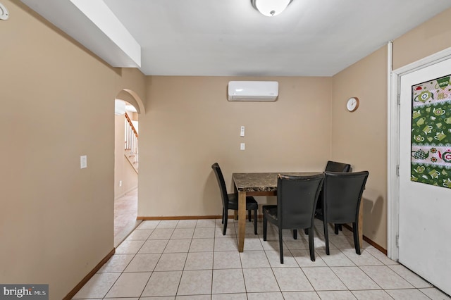 dining area with a wall mounted air conditioner and light tile patterned floors