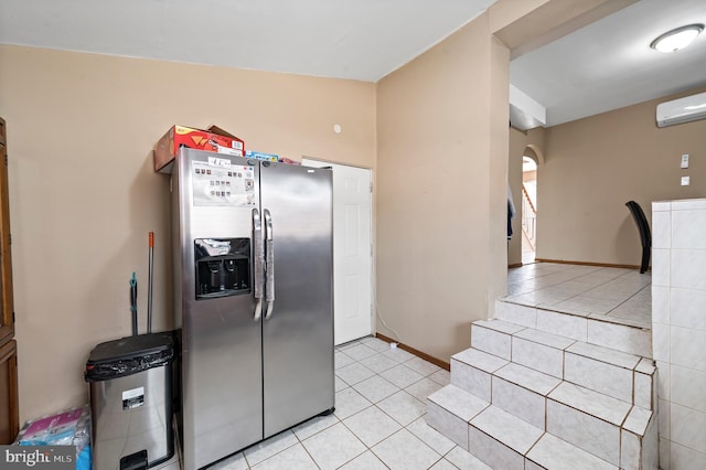 kitchen with light tile patterned flooring, a wall mounted air conditioner, and stainless steel fridge with ice dispenser