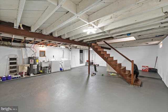 basement featuring sink, electric water heater, and washing machine and dryer