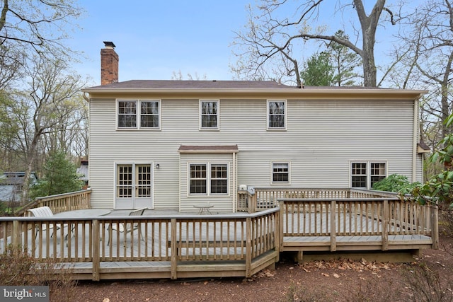 back of house featuring a chimney