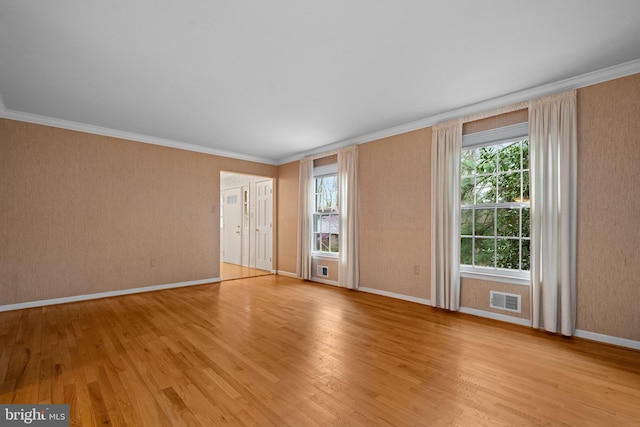 interior space with crown molding, visible vents, and light wood finished floors