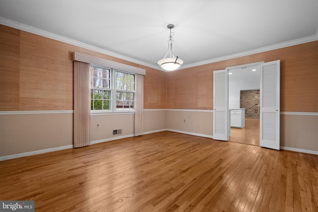 unfurnished dining area featuring crown molding, baseboards, and light wood-type flooring