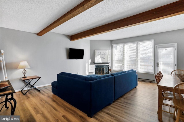 living room with hardwood / wood-style flooring, beam ceiling, and a textured ceiling