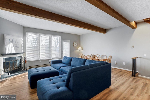 living room with beamed ceiling, a textured ceiling, light wood-type flooring, and baseboard heating