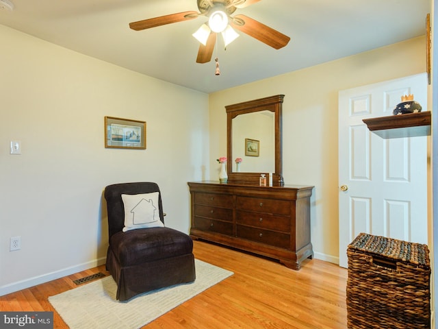 sitting room with ceiling fan and light hardwood / wood-style flooring