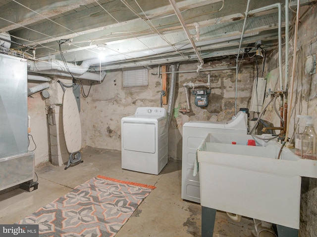 basement with heating unit, sink, and washer and dryer