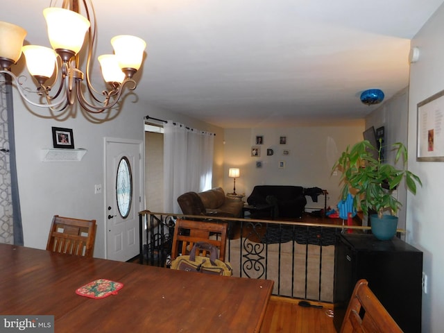 dining room with an inviting chandelier, wood-type flooring, and a barn door