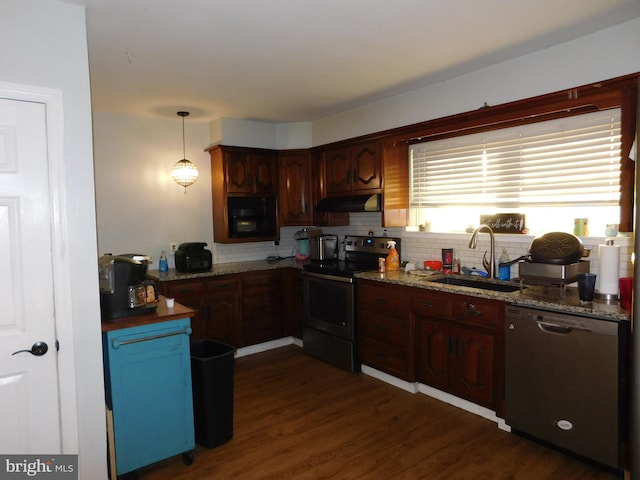 kitchen featuring sink, dark wood-type flooring, appliances with stainless steel finishes, decorative backsplash, and decorative light fixtures