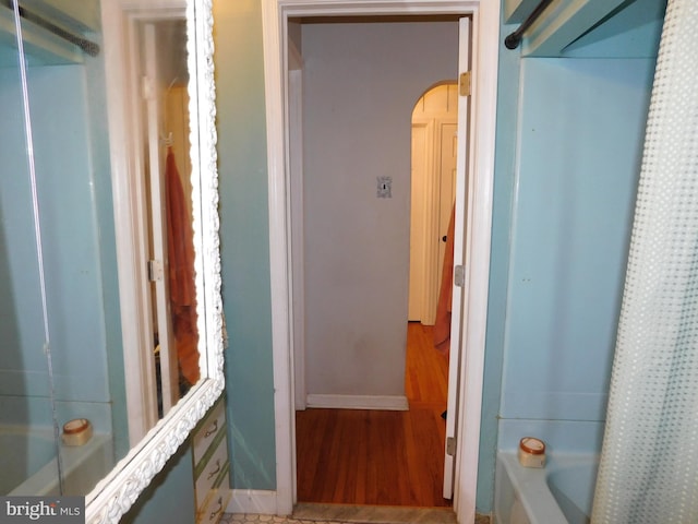 bathroom featuring hardwood / wood-style floors and shower / bath combo with shower curtain