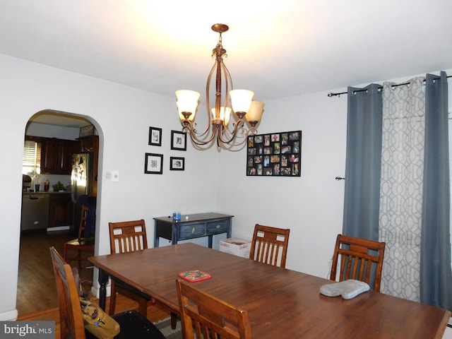 dining space with a notable chandelier and dark hardwood / wood-style flooring