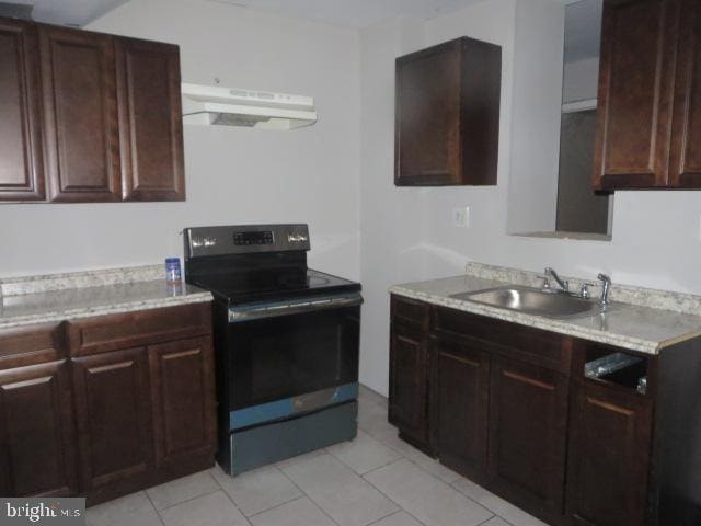 kitchen featuring electric stove, sink, and light tile patterned floors