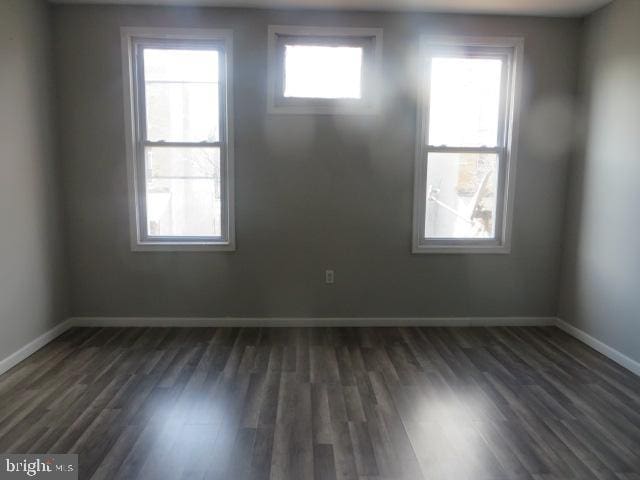 unfurnished room with dark wood-type flooring