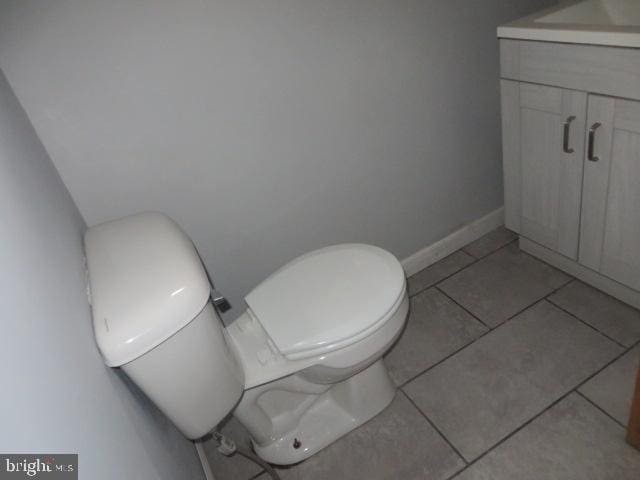 bathroom with tile patterned flooring, vanity, and toilet