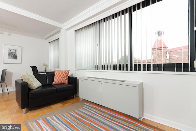 sitting room with radiator, crown molding, and light parquet flooring