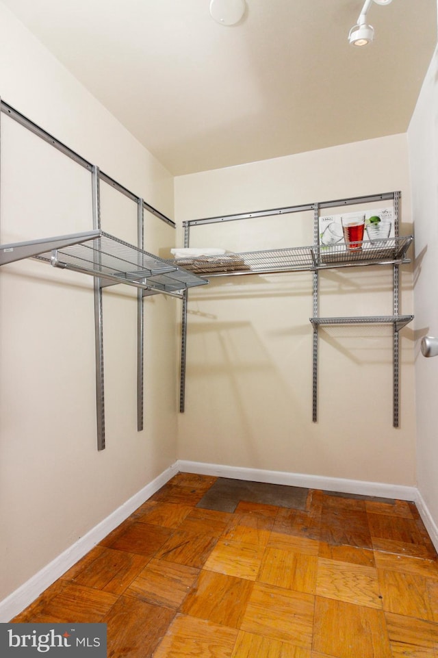 spacious closet featuring parquet flooring