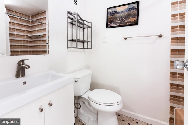 bathroom with vanity, toilet, and a tile shower