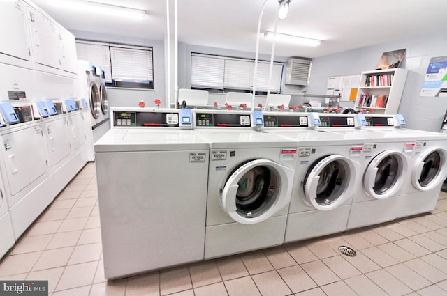 clothes washing area with light tile patterned flooring, stacked washer / drying machine, and washer and clothes dryer