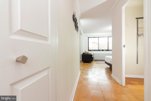 hallway with crown molding and light parquet floors