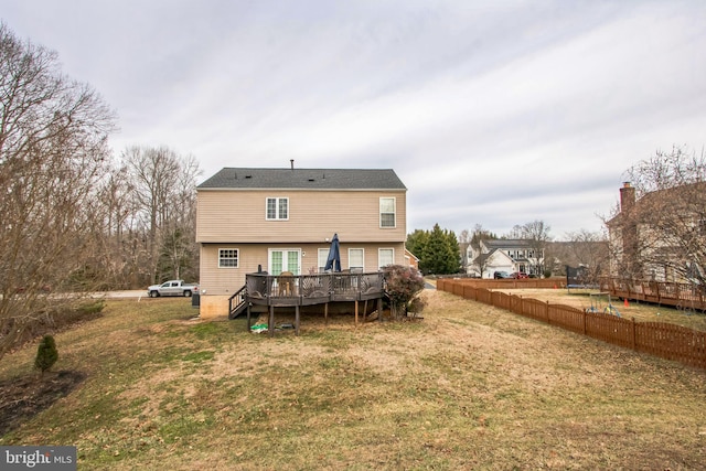 rear view of house featuring a wooden deck and a lawn