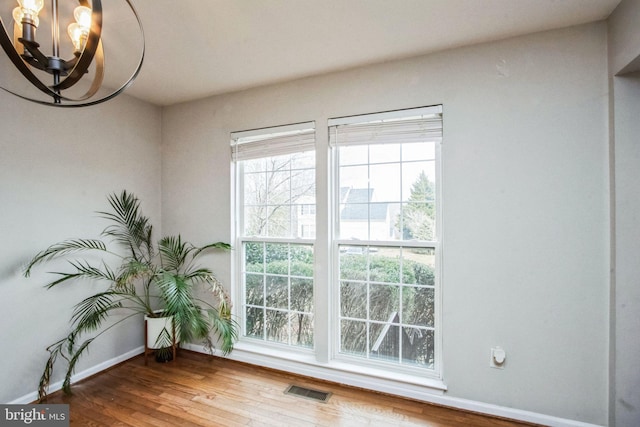 doorway to outside with hardwood / wood-style floors and a notable chandelier