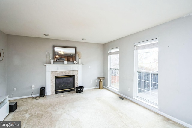 unfurnished living room featuring a premium fireplace and carpet