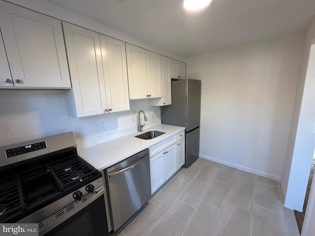 kitchen with stainless steel appliances, sink, decorative backsplash, and white cabinets