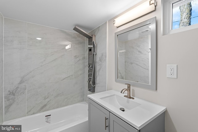 bathroom featuring tiled shower / bath and vanity