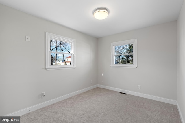 carpeted spare room featuring a healthy amount of sunlight