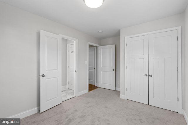 unfurnished bedroom with light carpet and a closet