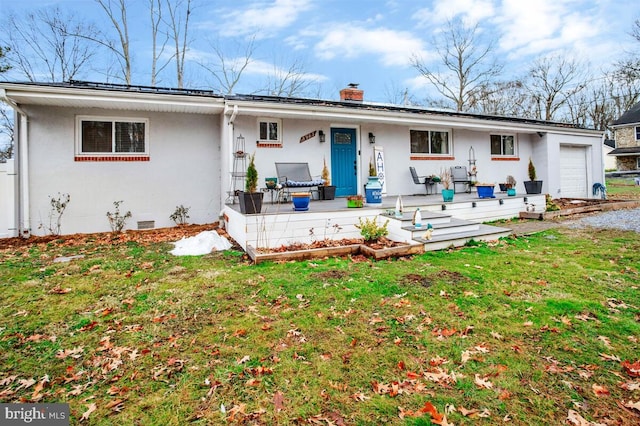 back of property featuring a garage and a yard