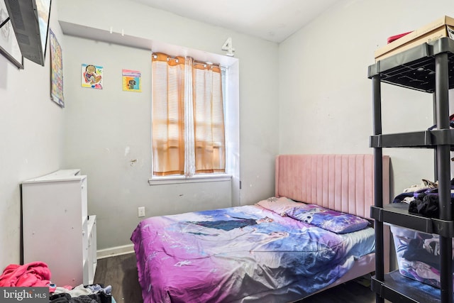 bedroom with dark hardwood / wood-style flooring