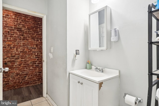 bathroom with vanity, brick wall, and tile patterned floors