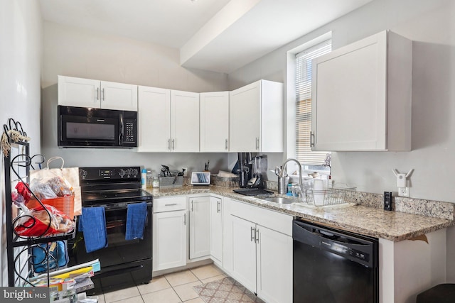 kitchen with white cabinetry, sink, black appliances, and light stone countertops