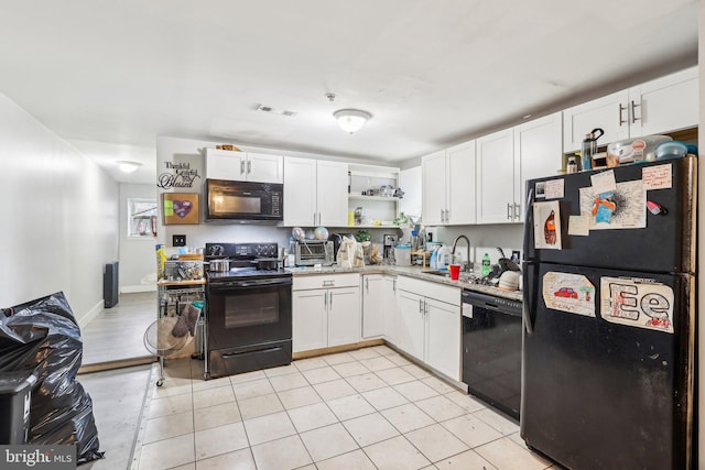 kitchen with light stone counters, white cabinets, sink, and black appliances