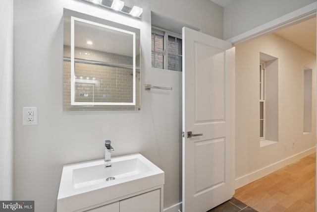 bathroom featuring vanity, wood-type flooring, and walk in shower