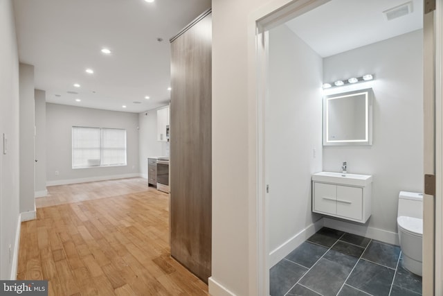 interior space featuring hardwood / wood-style flooring, vanity, and toilet