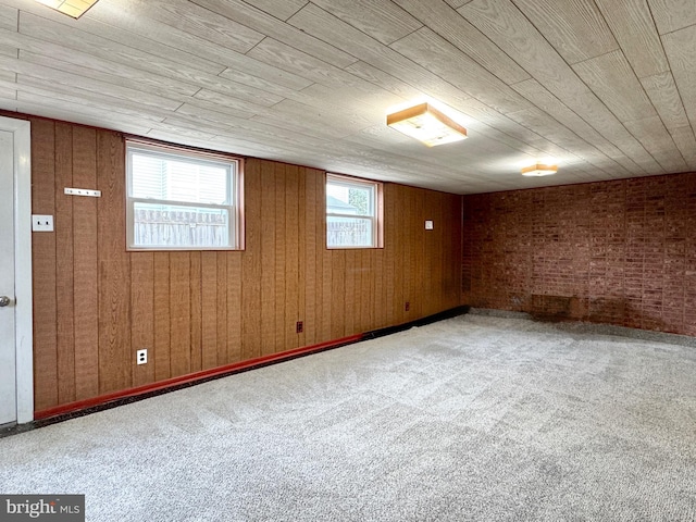 basement with wooden ceiling, wood walls, brick wall, and carpet