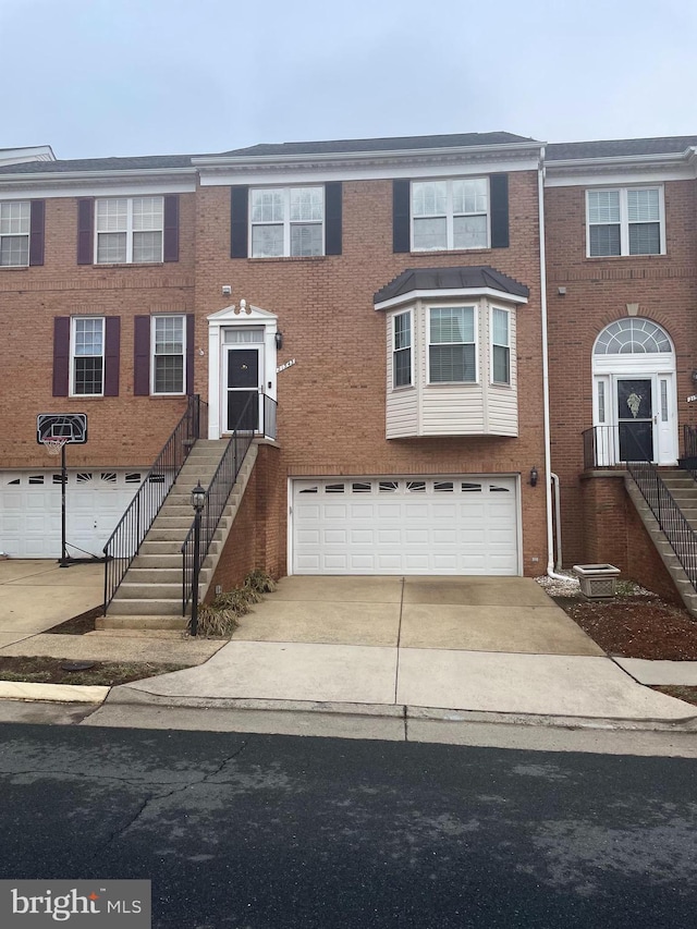 multi unit property featuring central AC unit and a garage