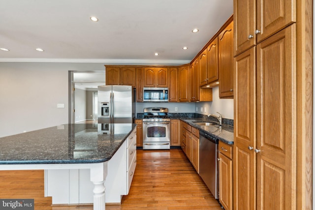 kitchen featuring a kitchen island, stainless steel appliances, light wood-type flooring, a sink, and recessed lighting