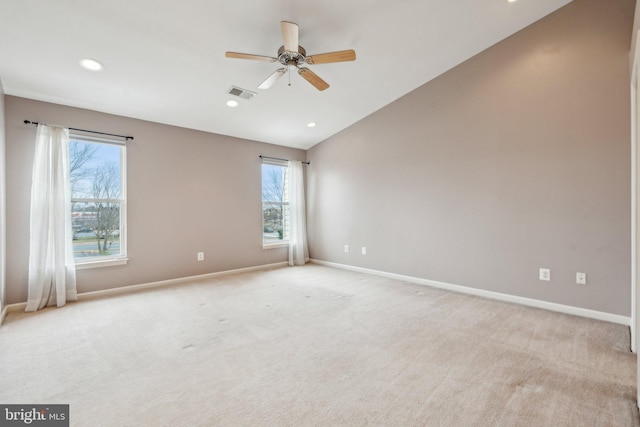 spare room with recessed lighting, light colored carpet, visible vents, vaulted ceiling, and baseboards