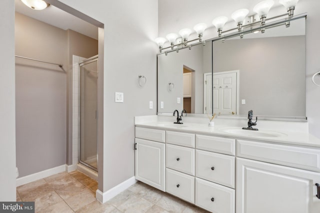 full bath featuring a stall shower, a sink, and double vanity