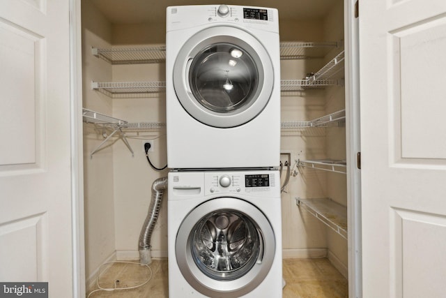 laundry room with laundry area, stacked washing maching and dryer, and tile patterned flooring