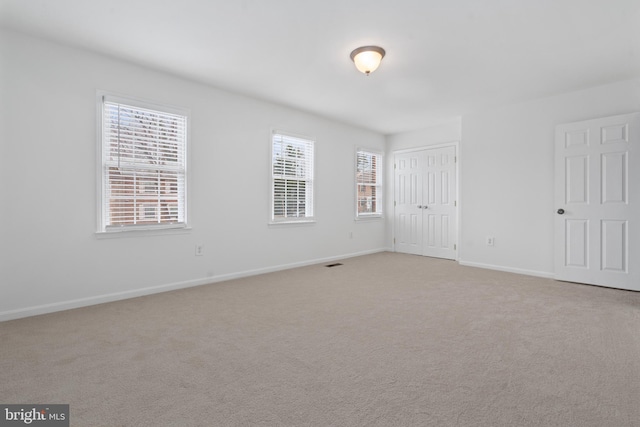 unfurnished room featuring light colored carpet